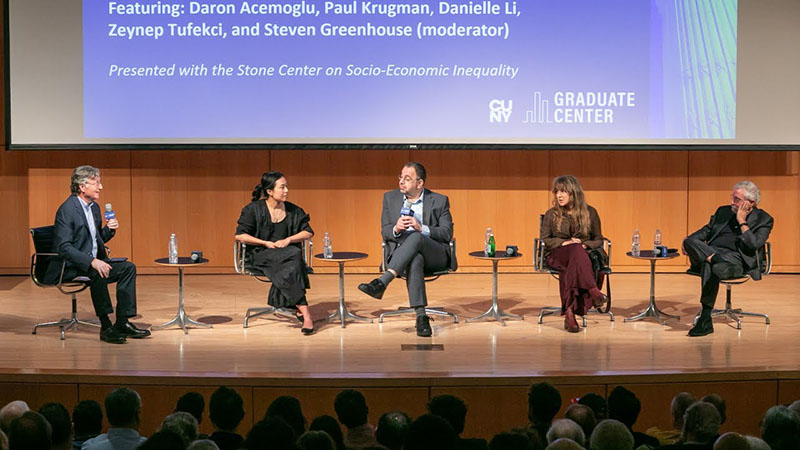 Panelists discuss AI and the future on work on stage at the CUNY Graduate Center.
